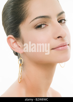 Frau trägt Ohrringe Stockfoto