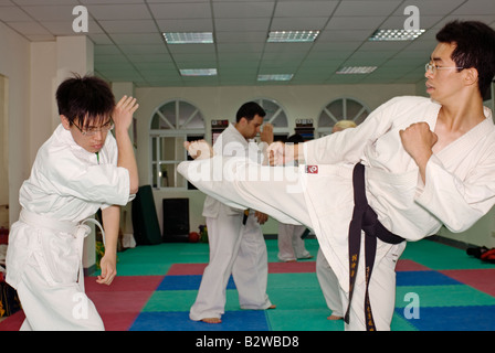 Lehrer treten und Schüler Verteidigung kick im Kickboxen Klasse, Taiwan, China Stockfoto