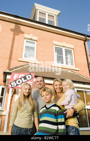 Familie außerhalb neues Haus Stockfoto