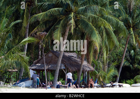 Besucher entspannen unter Palmen am weißen Sandstrand Cham Island vor historischen Hoi An Vietnam Stockfoto