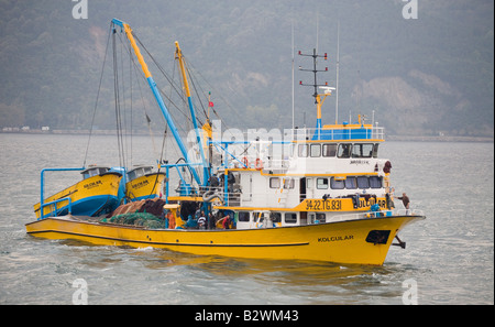 Gelbe Bosporus Fischerboot. Ein fischender Trawler Kolcular mit seiner kleinen Flitzer Kreuzfahrten an Bord am Bosporus Stockfoto