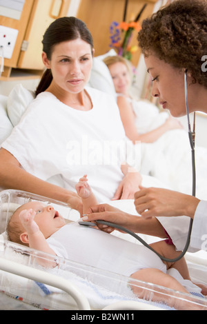 Arzt überprüft Baby Herzschlag mit neuen Mutter beobachten Stockfoto