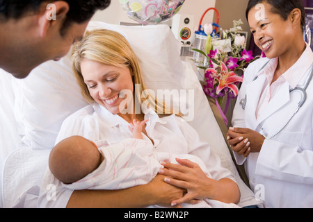 Junge Eltern mit Baby Rücksprache mit Arzt und lächelnd Stockfoto