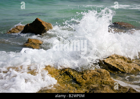 Spritzer der Wellen gegen die Felsen am Meer. Stockfoto