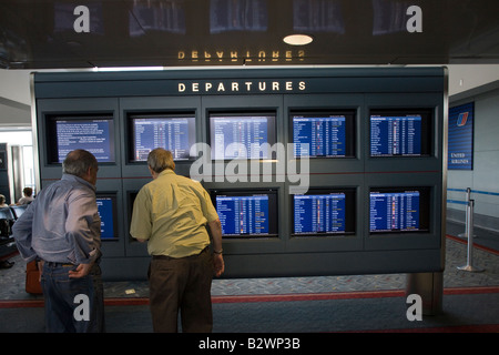 Passagiere auf Flug planen Videoterminals, internationalen Flughafen Denver, Colorado, USA Stockfoto