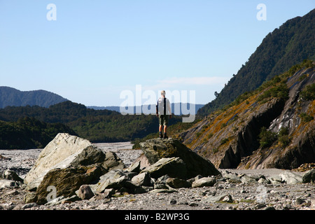 Ein Besucher genießt die Landschaft in Franz Josef Glacier in Westland NP, an der Westküste der Südinsel, Neuseeland Stockfoto