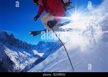 Skifahrer, die springen auf verschneiten Hügel (Lens Flare) Stockfoto