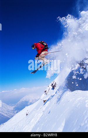 Skifahrer auf verschneiten Hügel springen Stockfoto