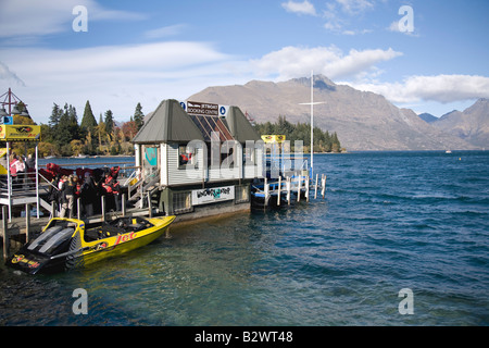 Leute warten auf das Jetboot am Kai am See wakatipu, Queenstown, Neuseeland Stockfoto
