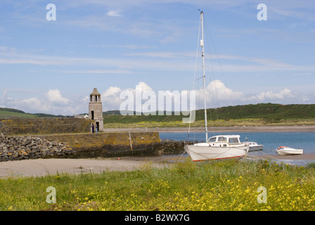 Die steinernen Pier und alte Granit-Leuchtturm am Hafen Logan Hafen mit Booten Dumfries und Galloway Schottland Vereinigtes Königreich UK Stockfoto