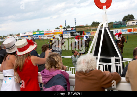 Zuschauern die Pferde der Zieldurchfahrt an der Rennstrecke Stockfoto