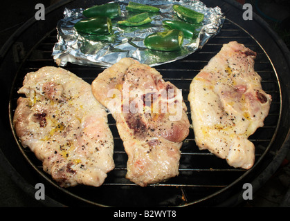 Rohe Schweinekoteletts und Jalapeño Paprika auf dem Grill Grillen. Stockfoto