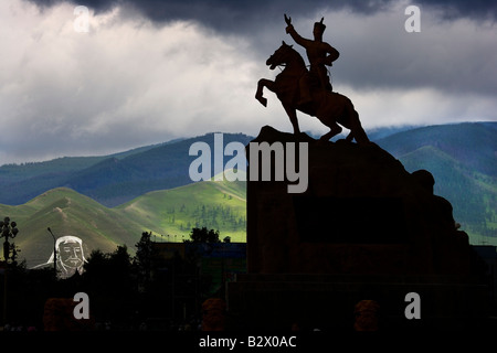 Die Statue des Helden Sukhbaatar wird durch ein riesiges Bild von Dschingis Khan in Kreide auf dem Hügel mit Blick auf die Stadt übersehen. Stockfoto