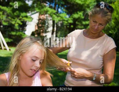 Mutter ihre Tochter Haare schneiden Stockfoto