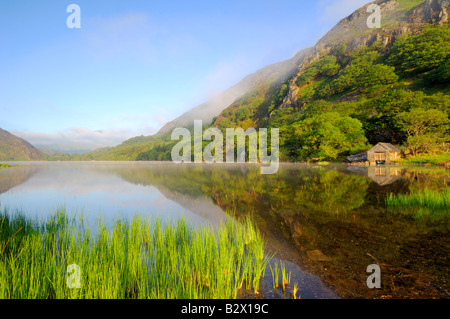 Ein kleines Bootshaus an einem wunderschön ruhig und nebligen Morgen in Llyn Dinas in Snowdonia-Nationalpark Nord-Wales Stockfoto