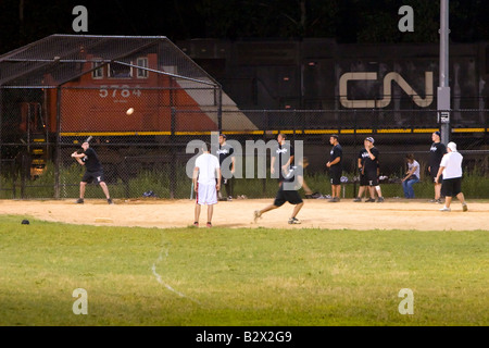 Ein Canadian National Güterzug fährt vorbei ein Softballspiel im Gange. Stockfoto