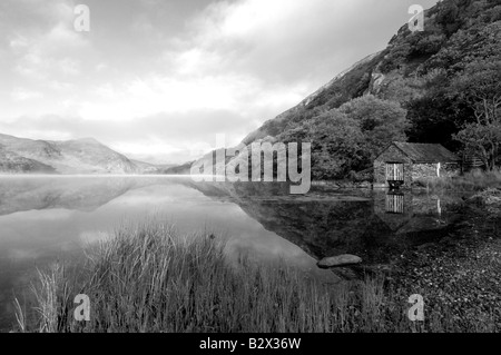 Ein kleines Bootshaus an einem wunderschön ruhig und nebligen Morgen in Llyn Dinas in Snowdonia Nationalpark Nord-Wales in mono Stockfoto