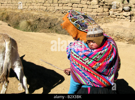 Frauen hüten ein Maultier mit einem Baby auf dem Rücken in Peru, Südamerika Stockfoto