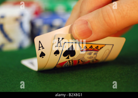 Mann die Hand heben Sie Spielkarten an einem Pokertisch Stockfoto