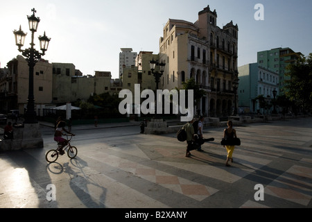 Menschen, die musikalischen Instrumente gehen Sie Prado Avenue zusammen mit einem Mädchen mit ihrem Fahrrad in Havanna, Kuba Stockfoto