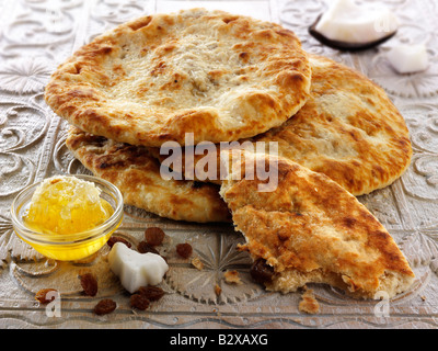 Peshwari Naan. Kokosnuss-Sultaninen und Honigbrot serviert bereit, auf einem Tisch zu essen - indische Küche Stockfoto