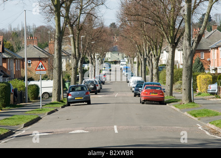 Autos, die auf einer Straße in einem Vorort mit schnellen Buckel geparkt wurden, um den Verkehr in Großbritannien zu verlangsamen. Stockfoto