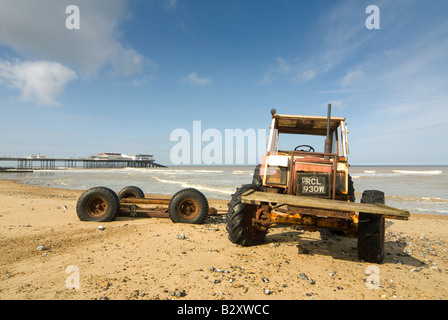 Traktor am Strand mit Mole in den Hintergrund bei Cromer Norfolk uk Stockfoto