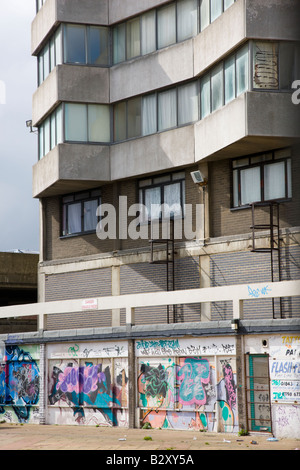 Graffiti auf Arcade von Geschäften unter einem Turm Wohnblock in Margate Kent Stockfoto