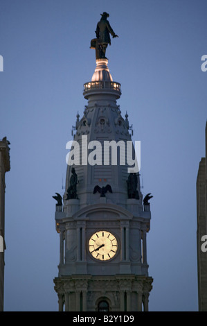 Statue von William Penn und Uhr auf der Oberseite Rathaus in der Abenddämmerung von Broad Street, Philadelphia, PA Stockfoto