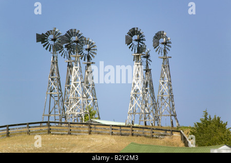 Alte hölzerne Windmühlen sitzen am Hang oberhalb Bauernhof in Nebraska Stockfoto