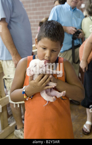 Latino Boy halten Baby Schwein an Iowa State Fair, Des Moines, Iowa, August 2007 Stockfoto