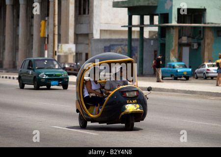 Ein Coco-Taxi fährt entlang des Malecon in Havanna, Kuba Stockfoto