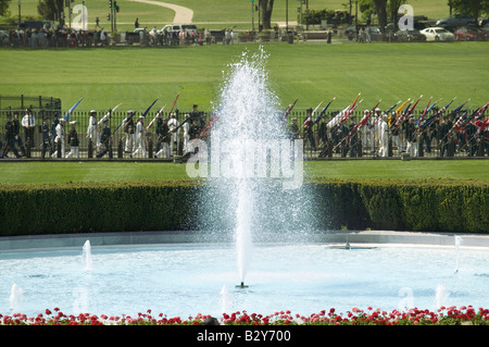 Eine Nahaufnahme des weißen Hauses Süd Brunnens als militärische Mitglieder im Hintergrund führen die fünfzig Zustandsflags Stockfoto