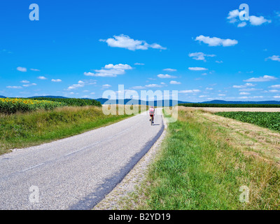 EINSAME RADFAHRER AUF DER LANDSTRAßE ELSASS FRANKREICH Stockfoto