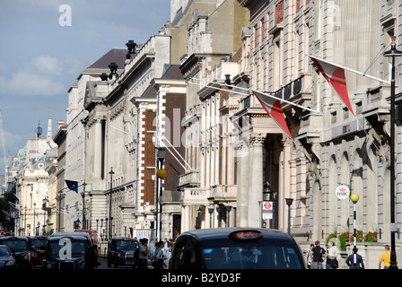 Blick entlang der Pall Mall mit einem schwarzes Taxi vorbeifahrenden Taxis St James s London England Stockfoto