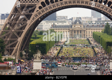 Gruppen von Menschen im Schatten des Eiffelturms und Parc du Champ de Mars im Hintergrund Paris Frankreich Stockfoto