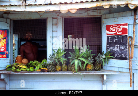 Eine lokale Belizean verkaufen frische Bananen, Ananas und Obst aus seiner Holzhütte Stockfoto