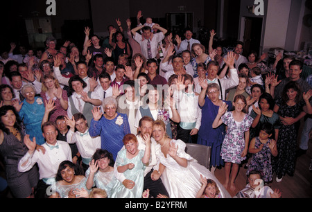 Hochzeit paar Umarmungen und Küsse während der Hochzeitsfeier und Gäste zum Lachen und Applaus Stockfoto