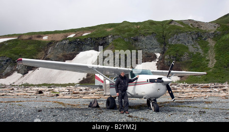 K-Bay Air Flugzeug (Cessna 206) und Pilot stehend auf einem Kiesstrand der Katmai-Nationalpark und Reservat, Alaska, Vereinigte Staaten Stockfoto