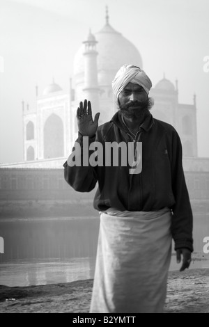 Ein schwarz-weiß Bild von einem Mann mit einem Turban, stehend vor dem Taj Mahal. Stockfoto