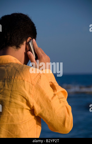 ein Geschäftsmann am Telefon in der Nähe des Meeres Stockfoto