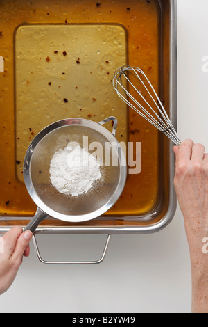 Hände, die Soße machen Stockfoto