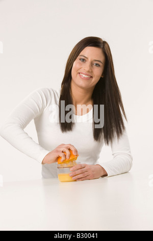 Frau auspressen Orangensaft Stockfoto