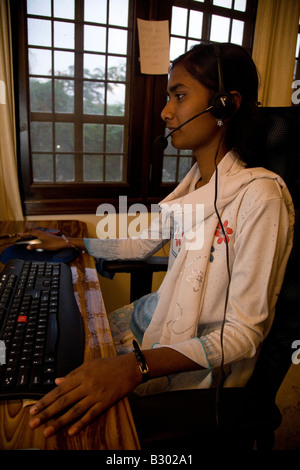 Ein Mitarbeiter in Bangalore arbeitet auf ihrem Computer in einem kleinen Büro. Stockfoto