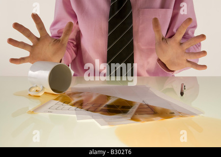 Geschäftsmann verschüttet Kaffee auf Dokumente Stockfoto