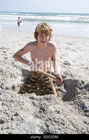 Junge Graben im Sand am Strand, Florida, USA Stockfoto