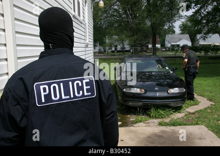 Polizisten aus Detroit NARC suchen den Hinterhof eines Hauses und ein Auto Stockfoto