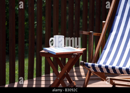 Einen erholsamen Sommer-Morgen-Tee und Buch auf der Terrasse Stockfoto