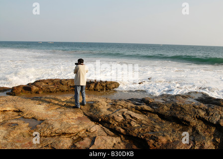 Eine Person, die Aufnahme von felsigen Strand von Kovalam, Kerala, Indien Stockfoto