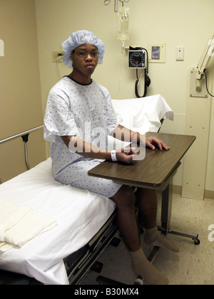 Schwarzer Mann, der auf dem Krankenhausbett sitzt Stockfoto